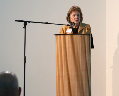 Dr Carolyn Bishop talks into a microphone from a podium.